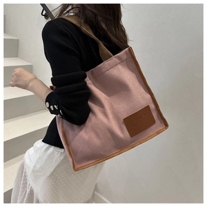 Close-up of pink waffle texture tote bag with brown trim and fashion leather patch