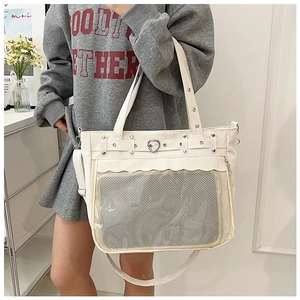 Détail du sac cabas blanc cassé avec poche en filet transparent et boucle cœur argentée