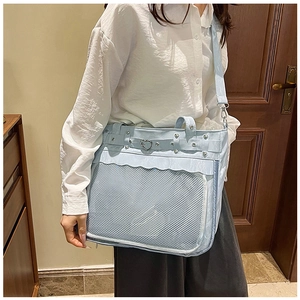 Detail of light blue PU leather tote bag with heart-shaped metal buckle and mesh pocket