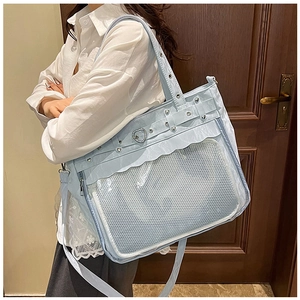 Detail of light blue ita bag showing transparent mesh pocket and ruffled heart buckle