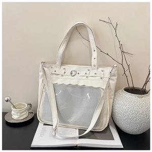Detail of white canvas tote bag with large clear window and heart-shaped metal buckles