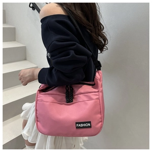 Pink nylon crossbody bag with black straps and zipper details for casual daily style