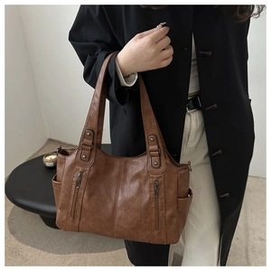 Détail d'un grand sac cabas vintage marron avec doubles poches zippées et rivets