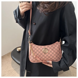 Pink monogram handbag with golden M logo styled on black coat for a trendy look