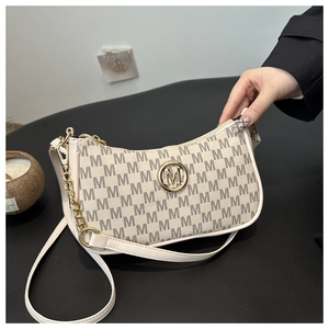 Close-up of vintage print handbag with golden M logo and elegant metal chain strap