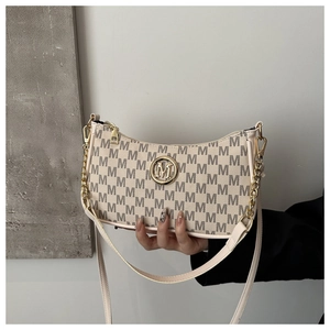 Detail of a beige handbag featuring grey M-pattern print and a gold circular M-logo