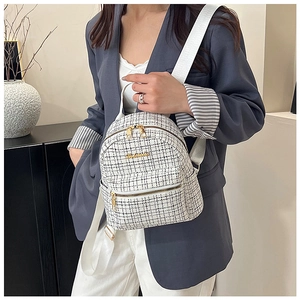 Détail d'un petit sac à dos en tweed noir et blanc avec logo et zip métalliques