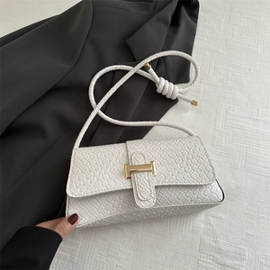 Bolso baguette minimalista de cuero tejido blanco con una hebilla metálica dorada en H