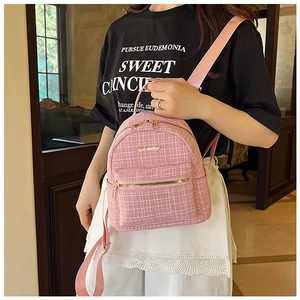 Détail du sac à dos en tweed rose avec fermetures dorées et texture tissée
