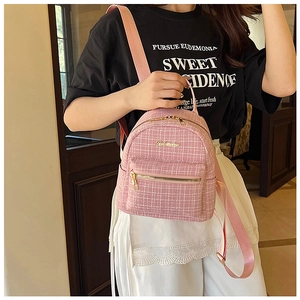 Détail d'un mini sac à dos en tweed rose à carreaux avec des fermetures éclair dorées