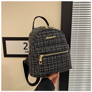 Vue détaillée d'un mini sac à dos en tweed avec fermetures éclair et accents dorés