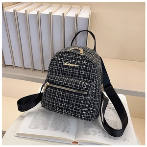 Détail d'un mini sac à dos élégant en tweed noir et blanc avec fermeture dorée chic