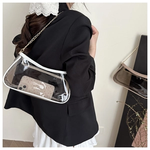Dettaglio borsa baguette in PVC trasparente con bordo in pelle bianca e catena oro