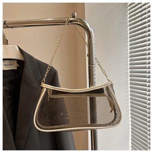 Detail of transparent PVC underarm bag with white leather piping and gold chain strap