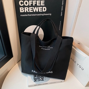 Large black canvas tote bag with white lettering for urban streetwear style