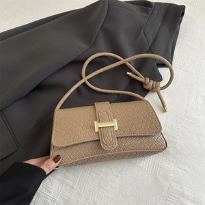 Bolso baguette color caqui con textura tejida y hebilla metálica dorada de moda