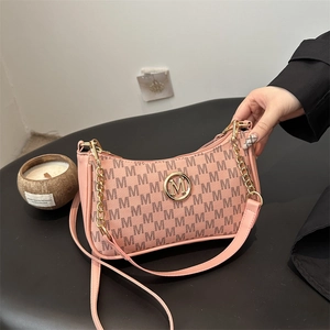 Pink monogram shoulder bag with gold M logo and chain strap on dark background