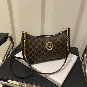 Retro shoulder bag with brown M-pattern print and gold M-logo on a leather chair