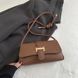 Bolso de hombro marrón con textura trenzada, hebilla dorada y detalle de correa anudada