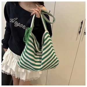 Detailed view of large canvas tote bag featuring green and white stripes and lace bow