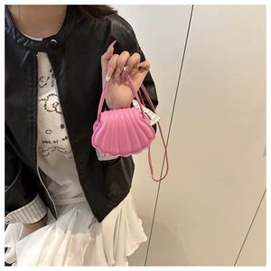 Detail shot of the pink shell-shaped mini crossbody bag with textured pleats