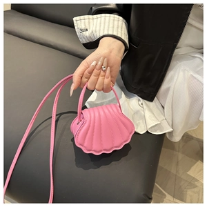 Detail of pink shell-shaped mini bag with quilted faux leather and slender strap