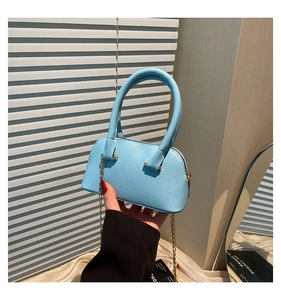Close-up of light blue lychee pattern leather shell bag with gold chain and handle