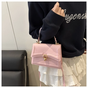 Close-up of pink crossbody bag with golden ring lock and fine stitching details