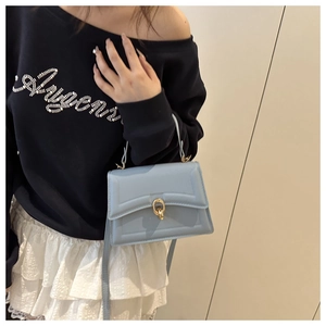 Close-up of light blue flap handbag with gold interlocking ring buckle and top handle