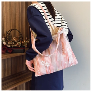 Dettaglio borsa tote in organza rosa con ricamo a margherita e fiocco in pizzo