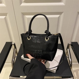 Elegante borsa a secchiello in pelle PU nera con lettere a rilievo e finiture oro
