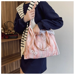 Detailed close-up of pink floral tote with white embroidery and lace trim details