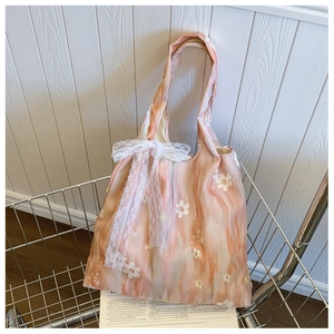 Detail of floral embroidery and lace bow on printed marble texture crossbody bag