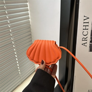 Orange shell-shaped crossbody bag with vertical quilted texture and thin shoulder strap