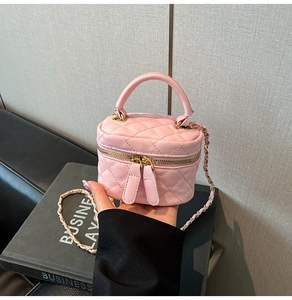 Detail of pink quilted mini box bag with gold-tone chain and dual zipper hardware