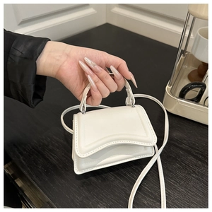Close-up of white matte PU leather mini bag with geometric embossed texture and metal clasp