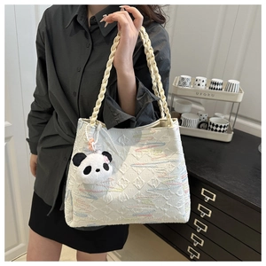 Detail of white quilted tote bag with rainbow embroidery and panda plush charm