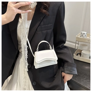 Close-up of a white mini crossbody bag with a unique wavy edge flap and matte finish