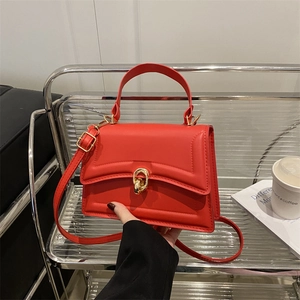 Fashionable red top-handle handbag with gold ring lock and adjustable strap