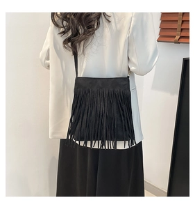 Detailed view of black matte PU leather crossbody bag with dense fringe accents