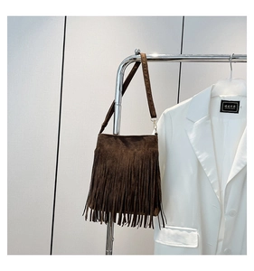 Detail of dark brown faux suede crossbody bag with vintage bohemian fringe design
