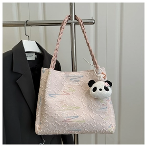 Détail du cabas en jacquard rose avec broderie ondulée et breloque panda