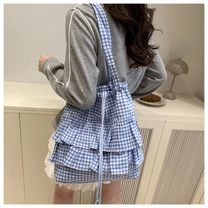 Detail view of blue gingham tote bag showing three-layer ruffle trim and drawstring