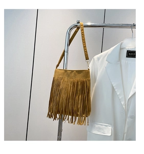 Detail view of ginger yellow tassel shoulder bag with bohemian fringe and suede texture