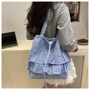 Detail of blue and white plaid tote bag with triple ruffles and drawstring closure