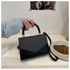 Détail du rabat texturé contrasté sur ce petit sac à bandoulière élégant pour femme