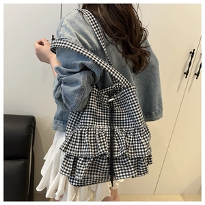 Detail of checkered tote bag featuring tiered ruffles and adjustable drawstring closure