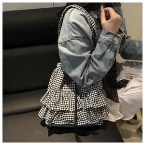 Detail view of the black and white gingham shoulder bag with multi-layer ruffle design