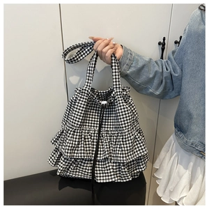 Detail of gingham tote bag featuring elegant double ruffles and drawstring closure