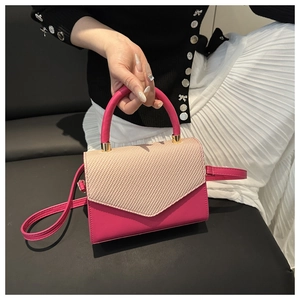 Détail du sac à main contrasté avec rabat en paille et texture en cuir fuchsia éclatant